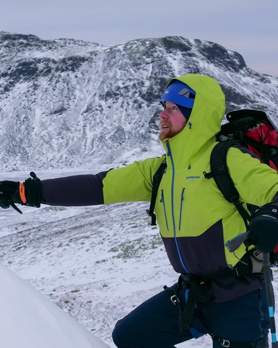 Jamie on a snowy mountain carrying an expedition pack and ice axe.